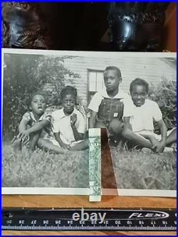 African American SchoolCOLORED STUDENTS SITTING ON GRASS HOLDING AMERICA FLAG