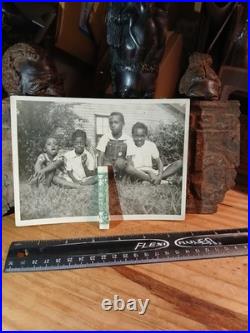 African American SchoolCOLORED STUDENTS SITTING ON GRASS HOLDING AMERICA FLAG