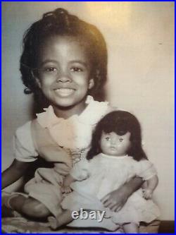 Beautiful African American little girl Holding a white baby doll