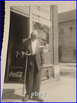 Colored business owner Looks at his hand Coke an 7up sign in background